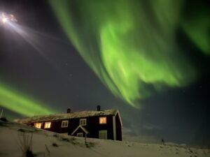 Nuestra casa en Noruega bajo la luz de las auroras boreales durante el invierno Ártico